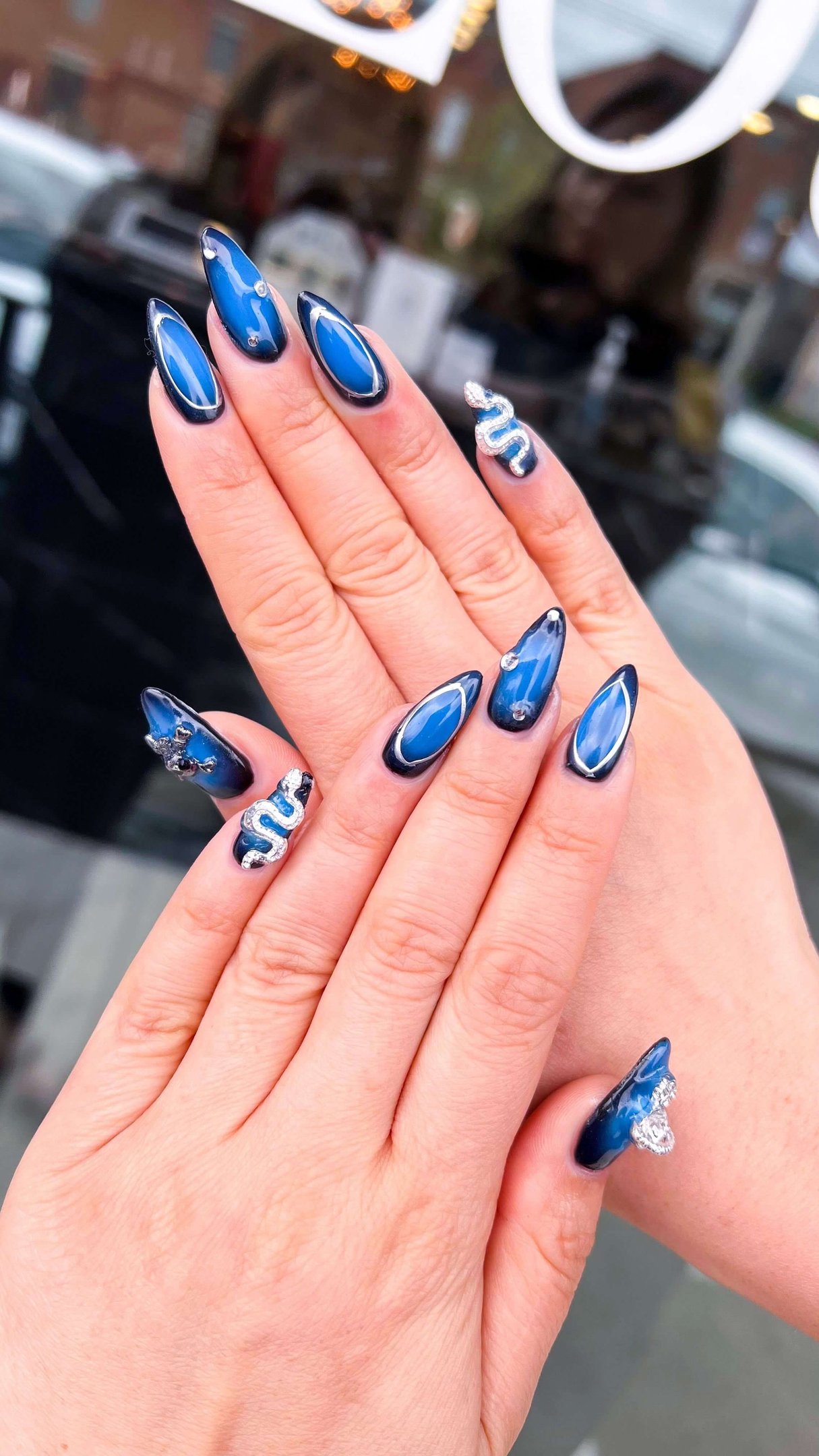 Deep navy and blue ombre fall nails with silver 3D crystal snake accents.
