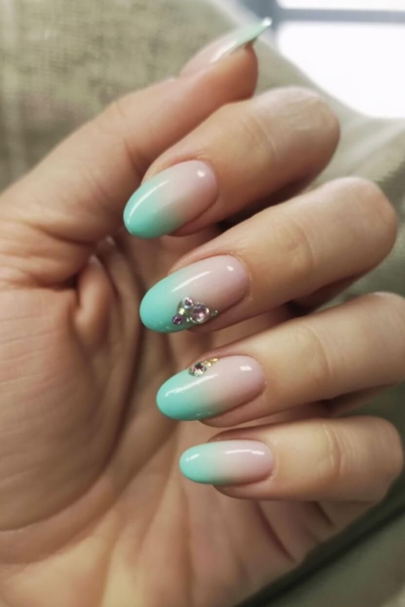 Sage green nails with neutral base and black leaf outlines finished with glitter tips – botanical in