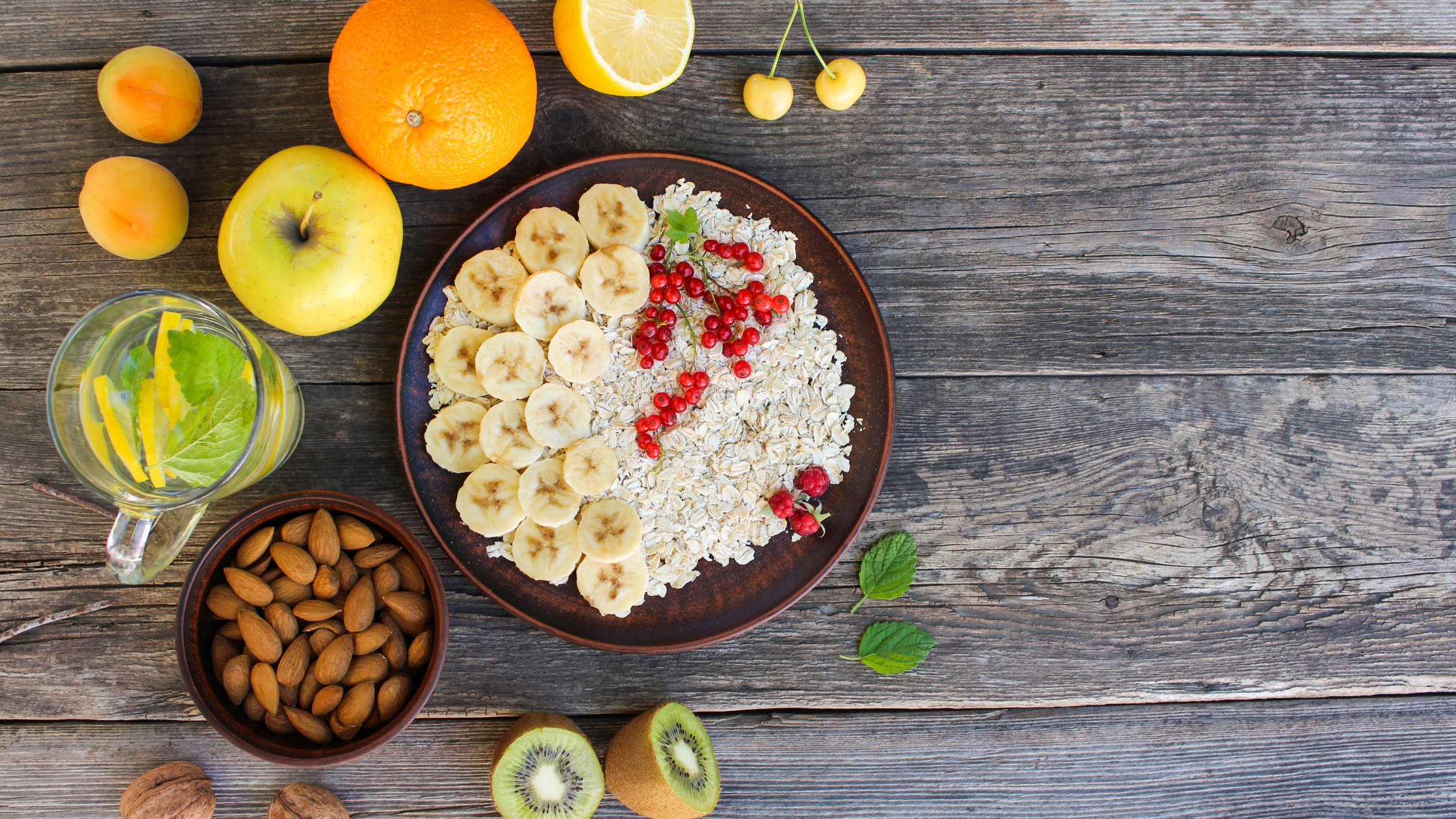 Healthy snacks with fresh fruits, oats, almonds, and lemon water for a natural body detox.
