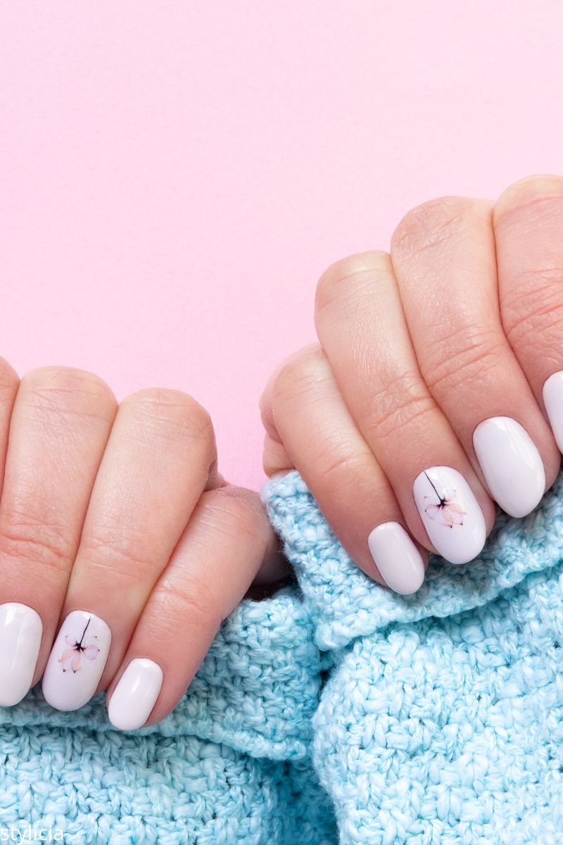 White gel nails with delicate pink flower design – elegant and minimal wedding nail idea for brides who love simple and classy manicures.
