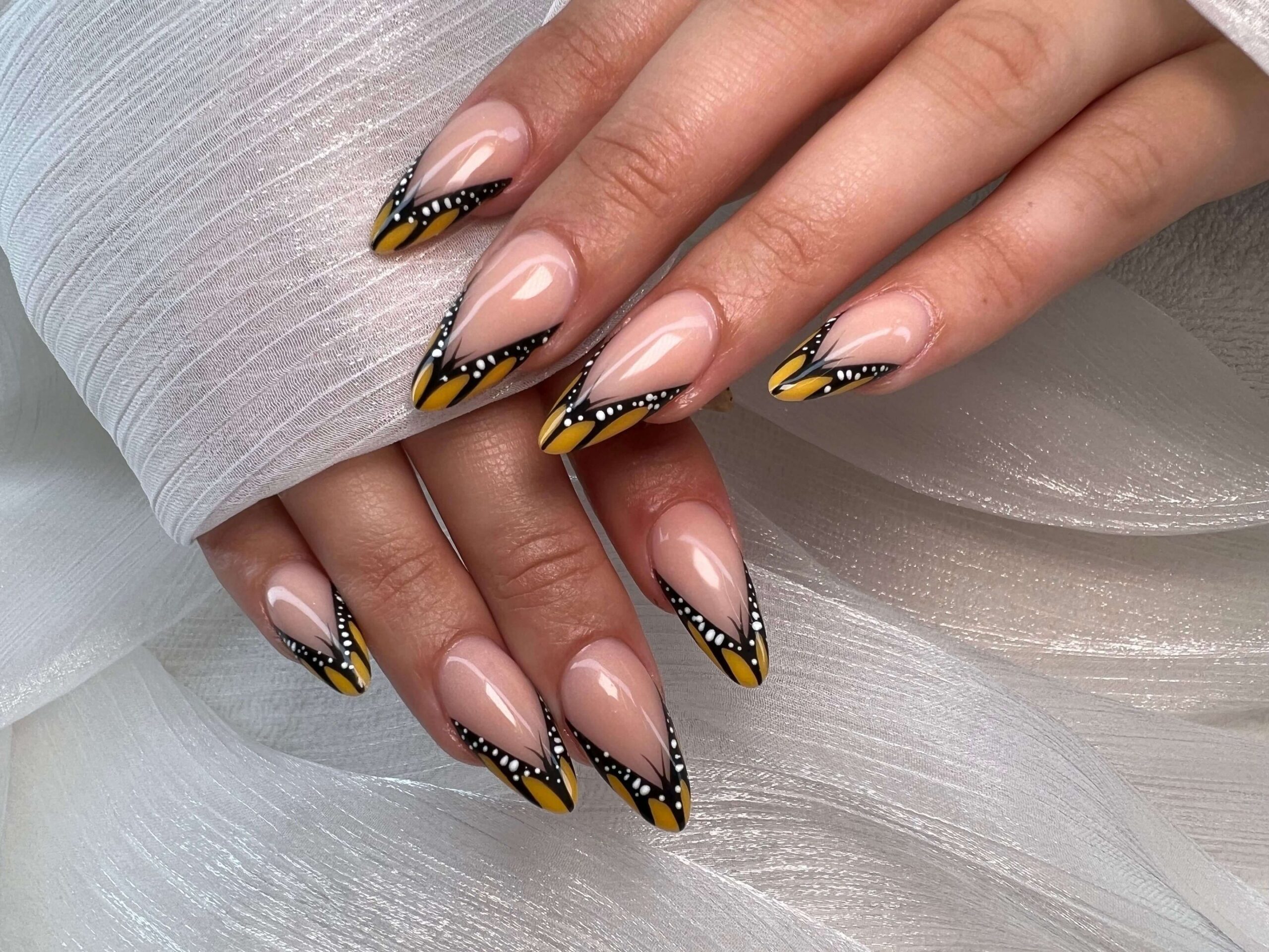 Square fall nails with orange leaf art, gold glitter ombre, and plaid accent designs.