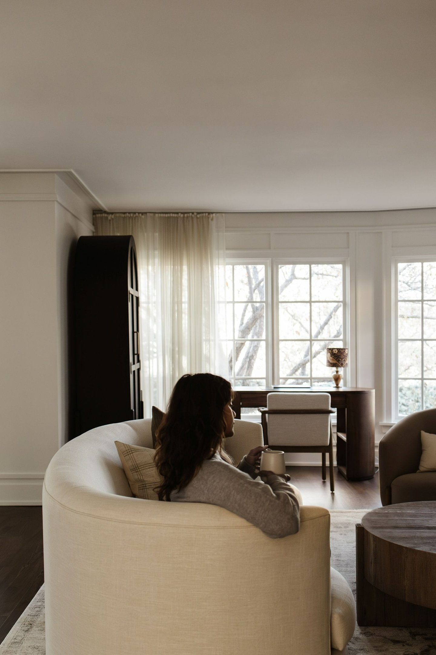 Bright narrow living room with floating sofa layout, sofa pulled away from wall, airy and inviting S