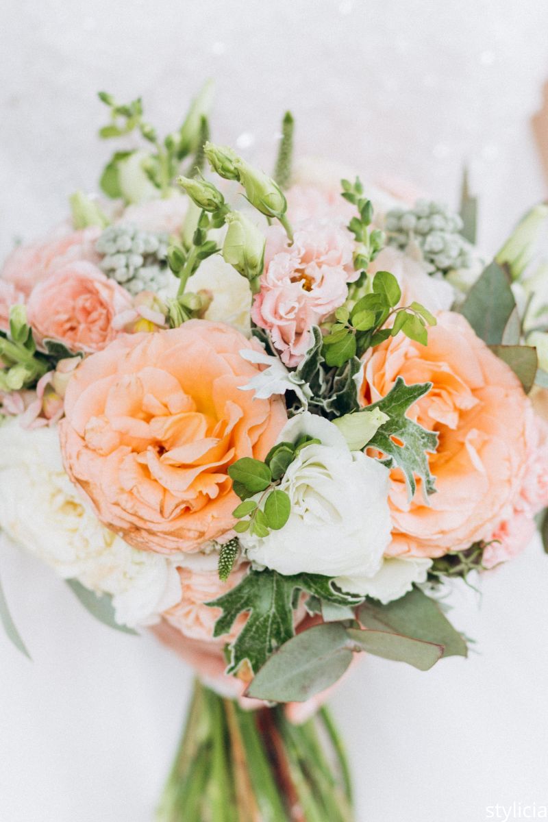 Close-up of pastel wedding bouquet with peach and white roses, symbolizing things wedding guests don’t care about floral details.