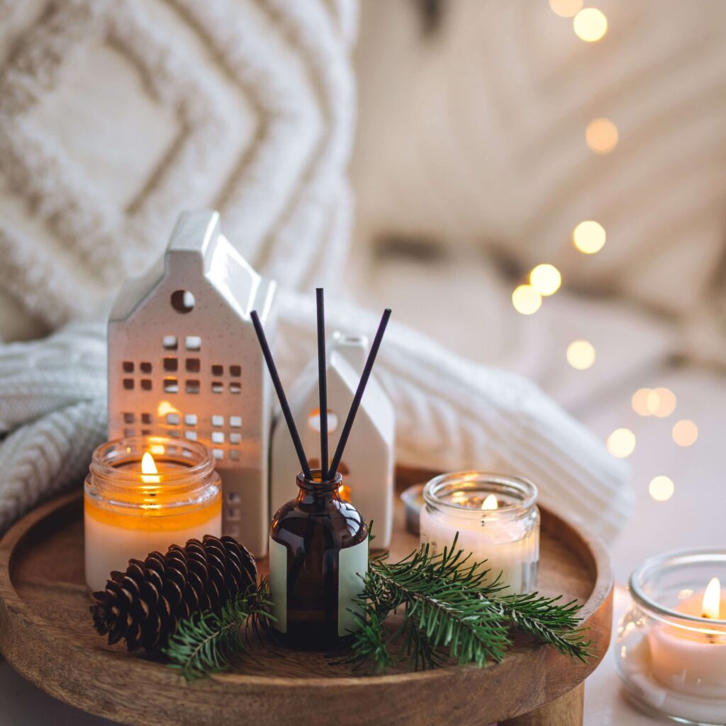 Cozy Christmas home décor with candles, pine branches, and warm lights — a peaceful reminder to get ready for Christmas in November by decorating with intention and creating a calm, inviting space.
