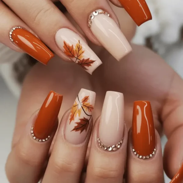 Fall nail ideas for every style — dark burgundy almond nails with orange and red maple leaves on white sheer base