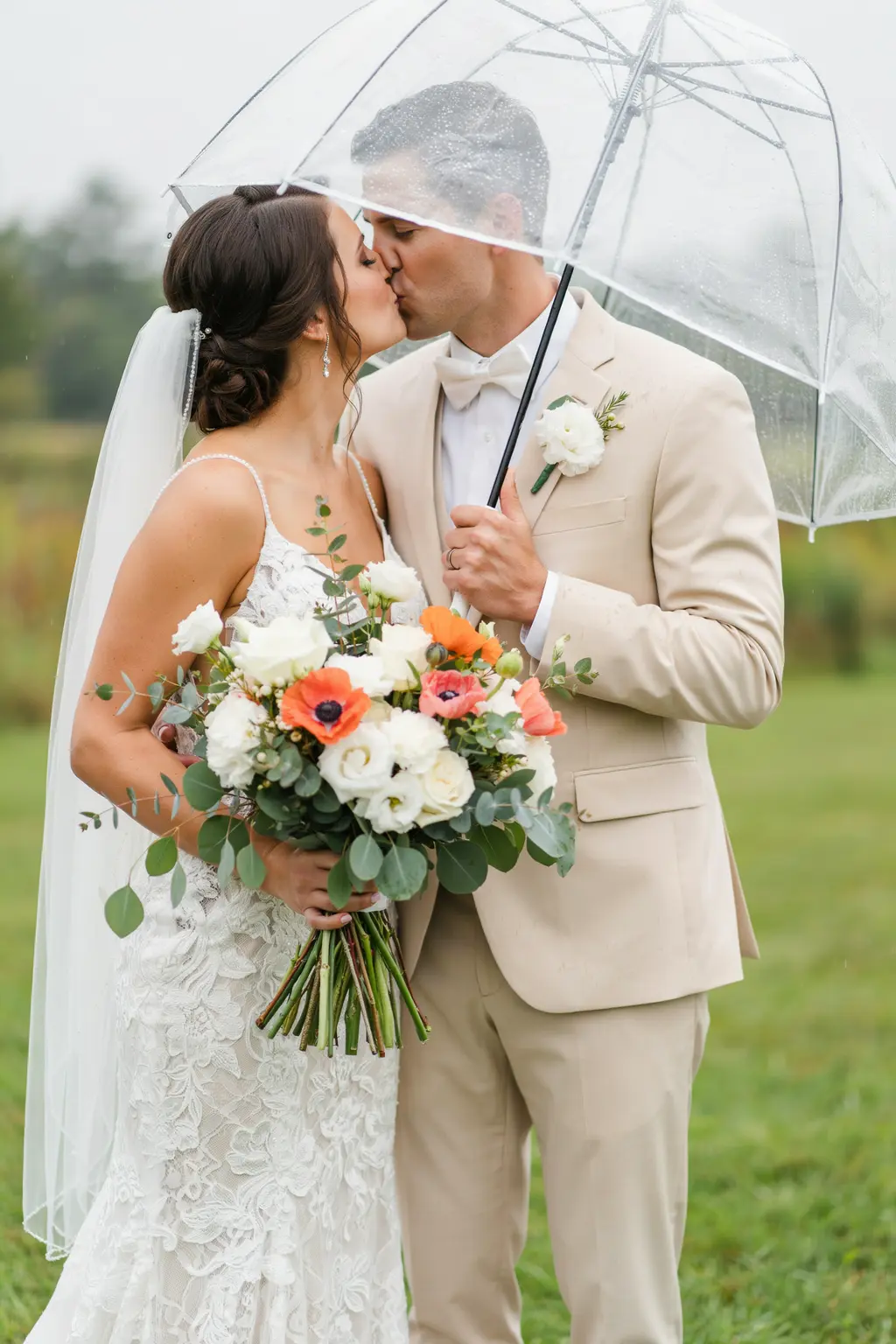 Fall outdoor wedding couple under matching clear bubble umbrellas with their faces still lit