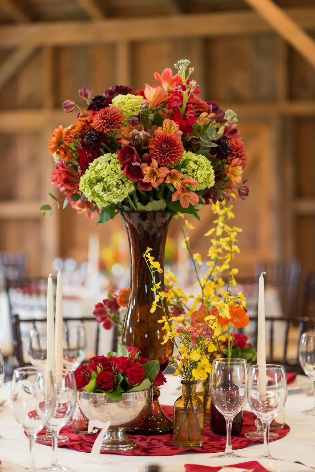 Fall wedding flowers that survive a warm tent: celosia, marigolds and hypericum berries still crisp at midnight
