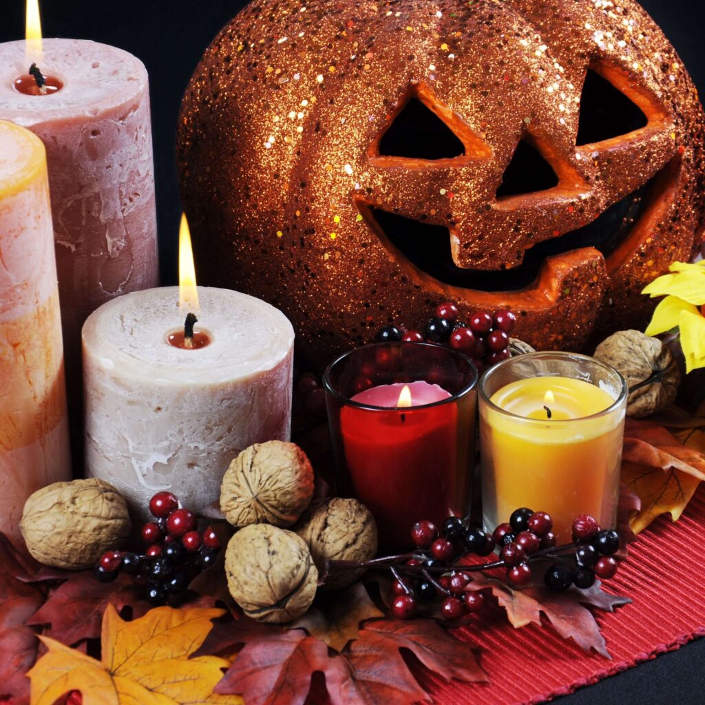 Rustic Thanksgiving centerpiece with glitter pumpkin, autumn candles, walnuts, berries, and fall leaves for a cozy holiday table décor