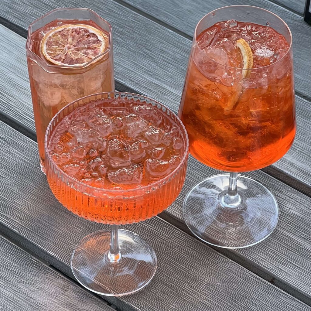 Cozy Maple Orange Spritz mocktail — a refreshing alcohol-free cocktail with maple syrup, citrus, and sparkling water. A perfect festive winter beverage for healthy holiday gatherings.