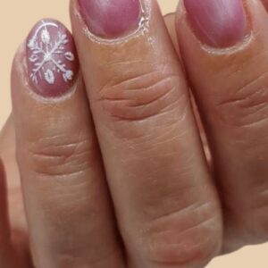 soft pink Christmas nails 2025 with white snowflake design