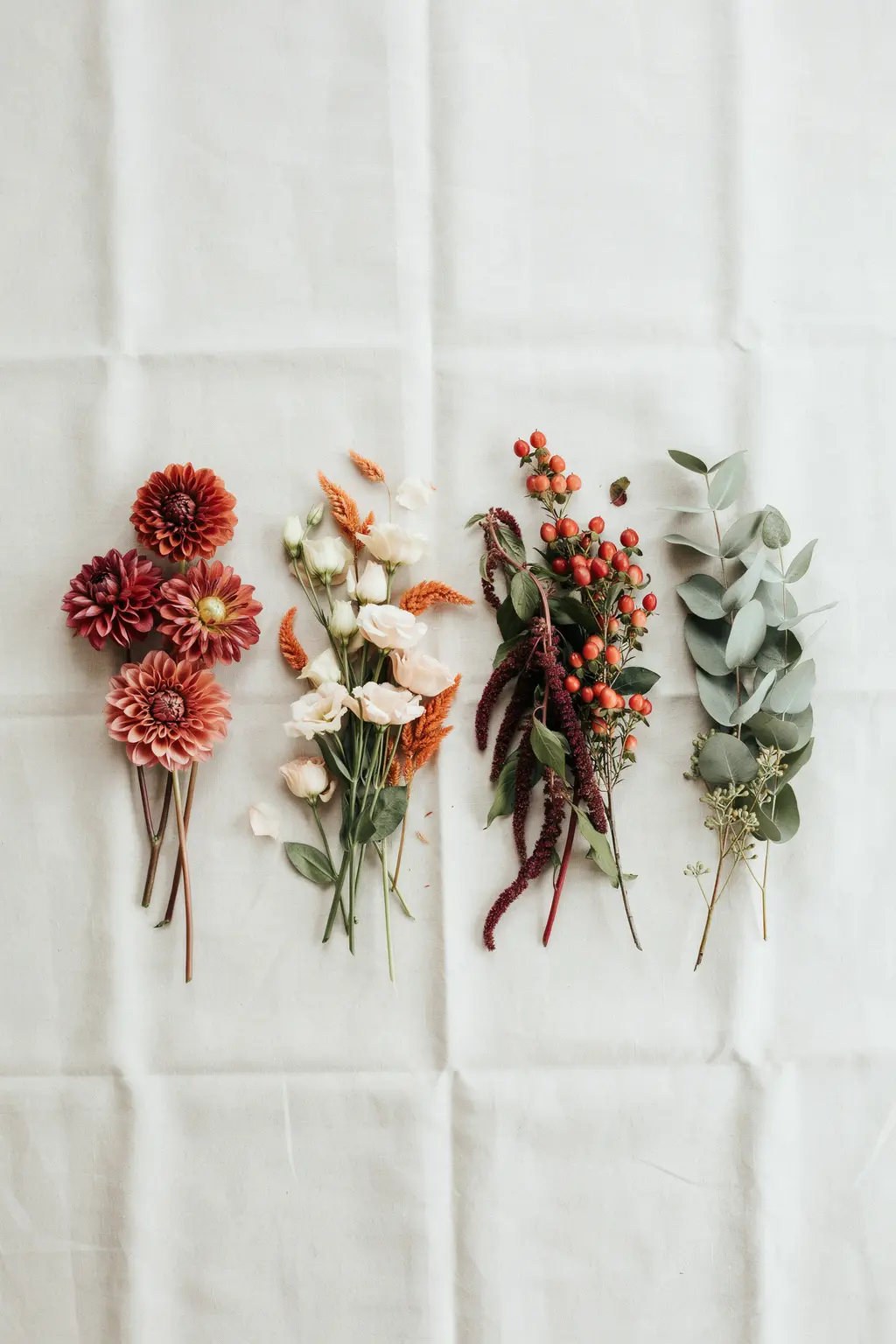 Fall wedding flowers sorted into four groups: open dahlias, smaller blooms, textural amaranth and greenery last